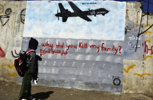 Figura 1. Niño mirando un grafiti en un muro en Saná (Yemen), que muestra un drone de EEUU con la inscripción en rojo: ¿por qué mataste a mi familia?. Fuente: Yahya Arhab/EPA.